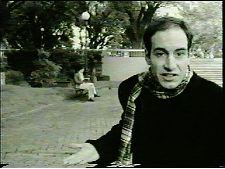 Senorita de saco gris que lee por la tarde en esta plaza